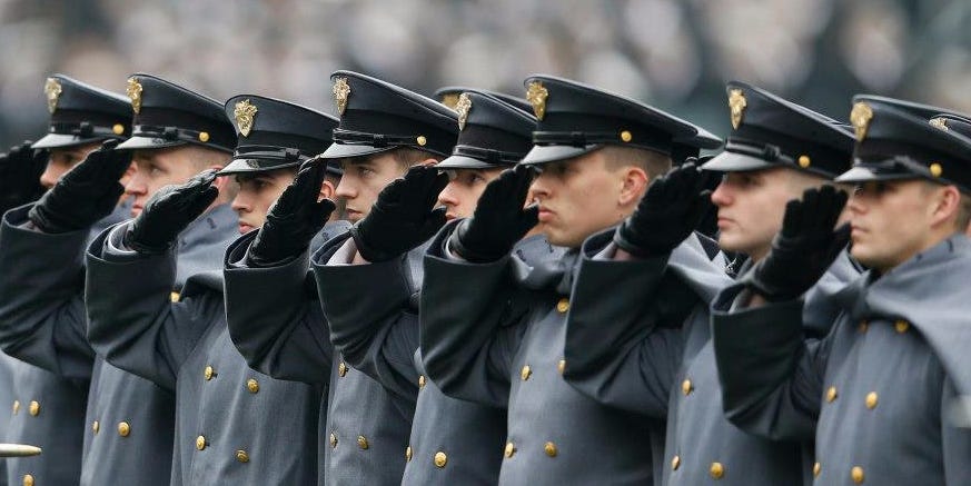 Image shows a row of soldiers saluting